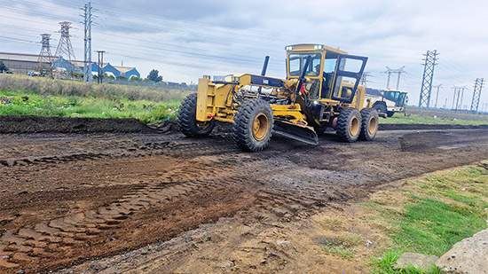Heavy machinery grading Cemetery Road during rehabilitation works